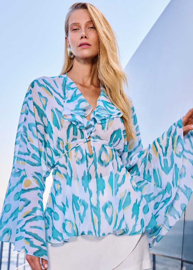 Woman wearing a colorful patterned blouse with a blurred background