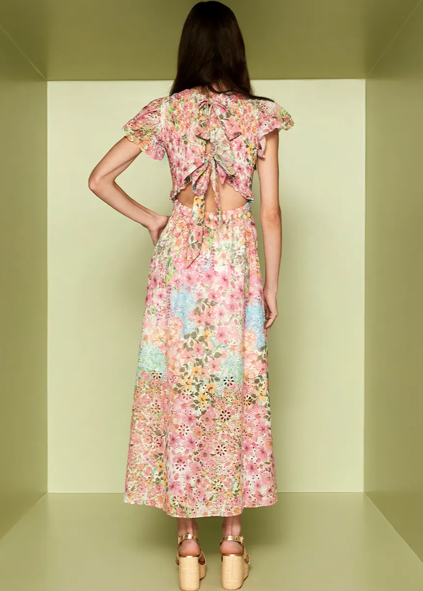 Woman wearing a floral dress with a cut-out back in a minimalistic setting