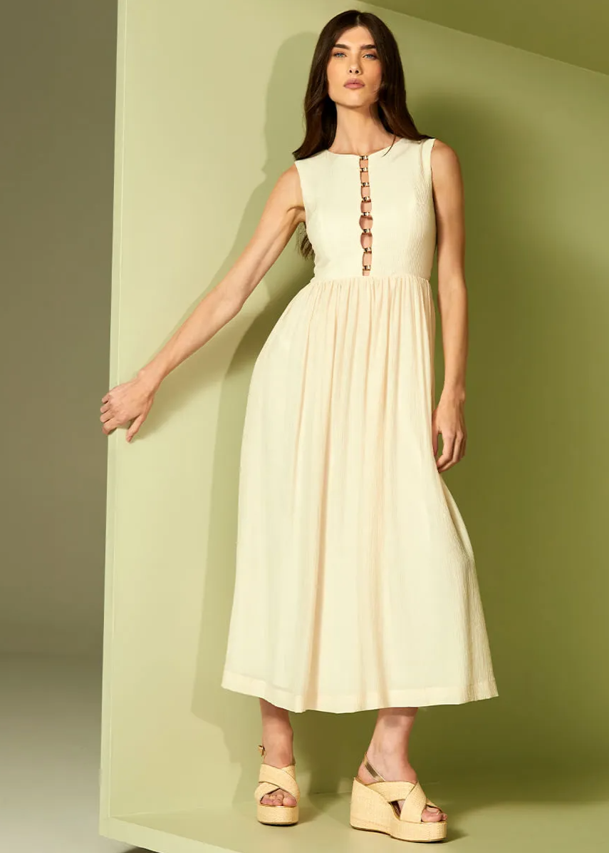 Woman wearing a light-colored dress against a green background