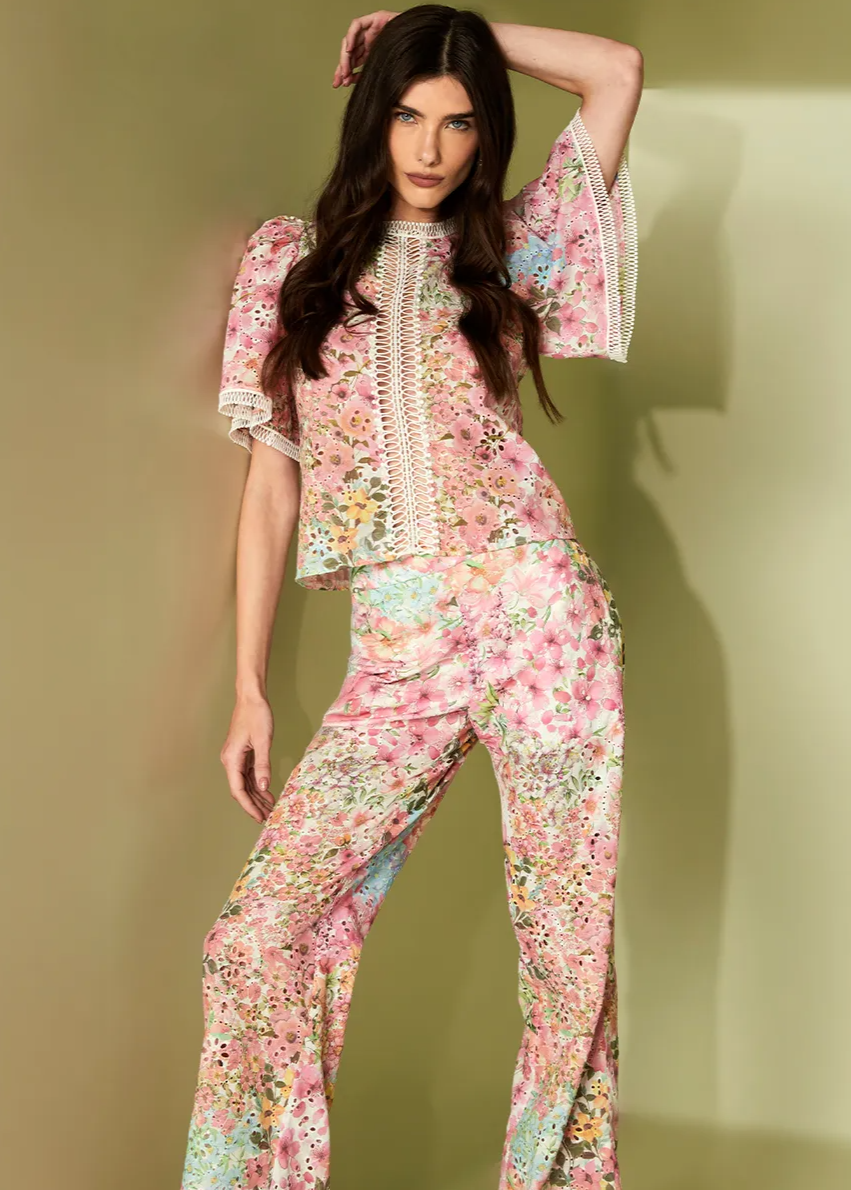 Woman wearing a floral outfit against a plain background