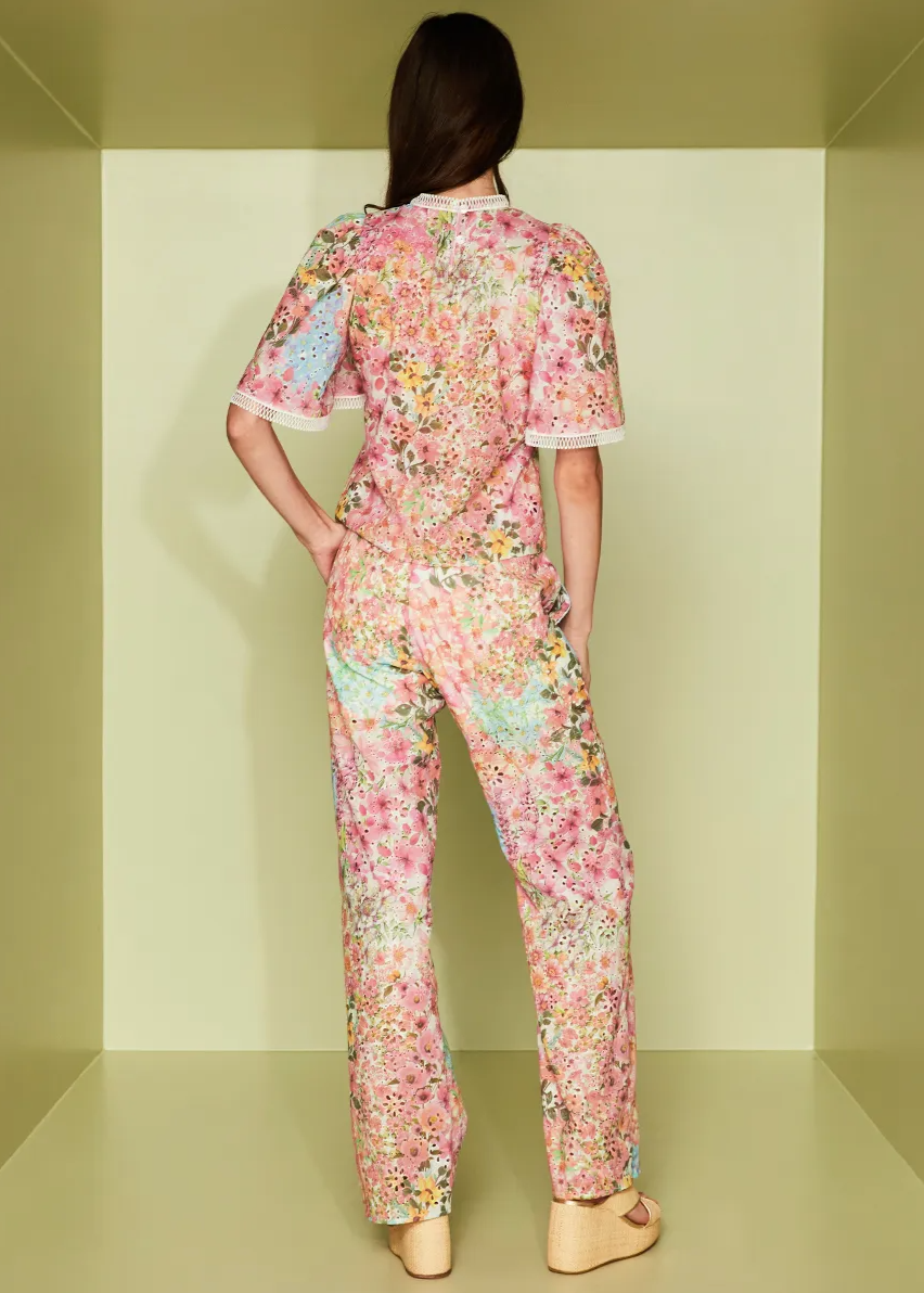 Person wearing a floral pajama set in a minimalistic room.