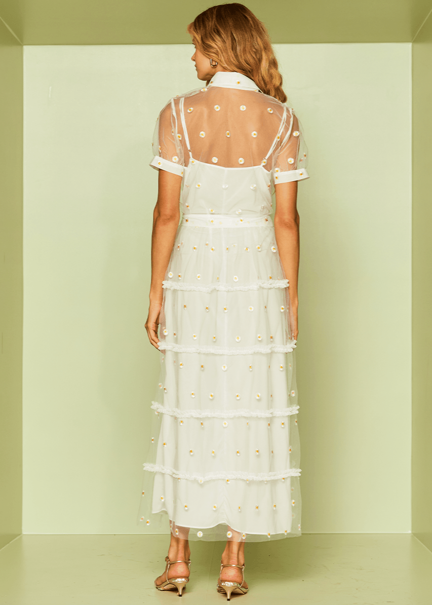 Woman wearing a white dress with polka dots in a minimalistic setting