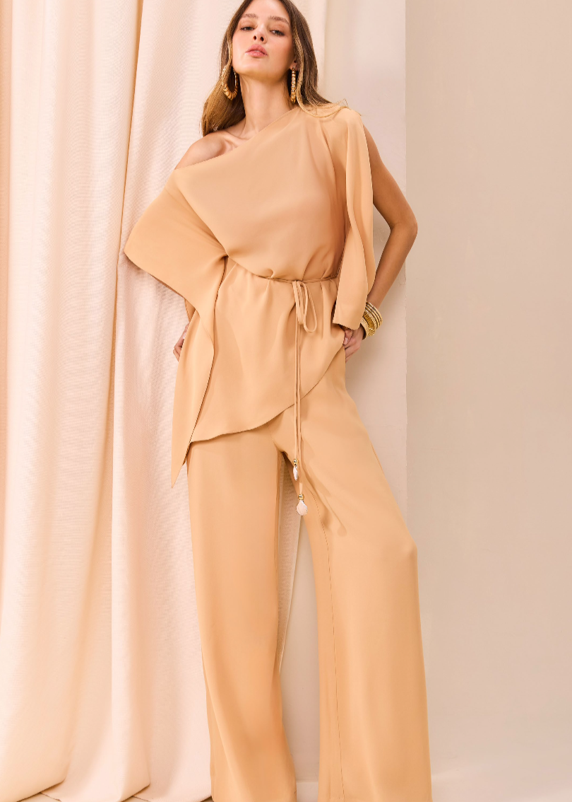 Woman wearing a beige outfit against a plain background