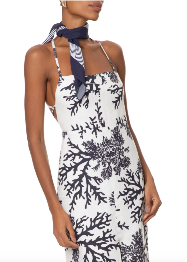 Woman wearing a white dress with black coral pattern and navy scarf