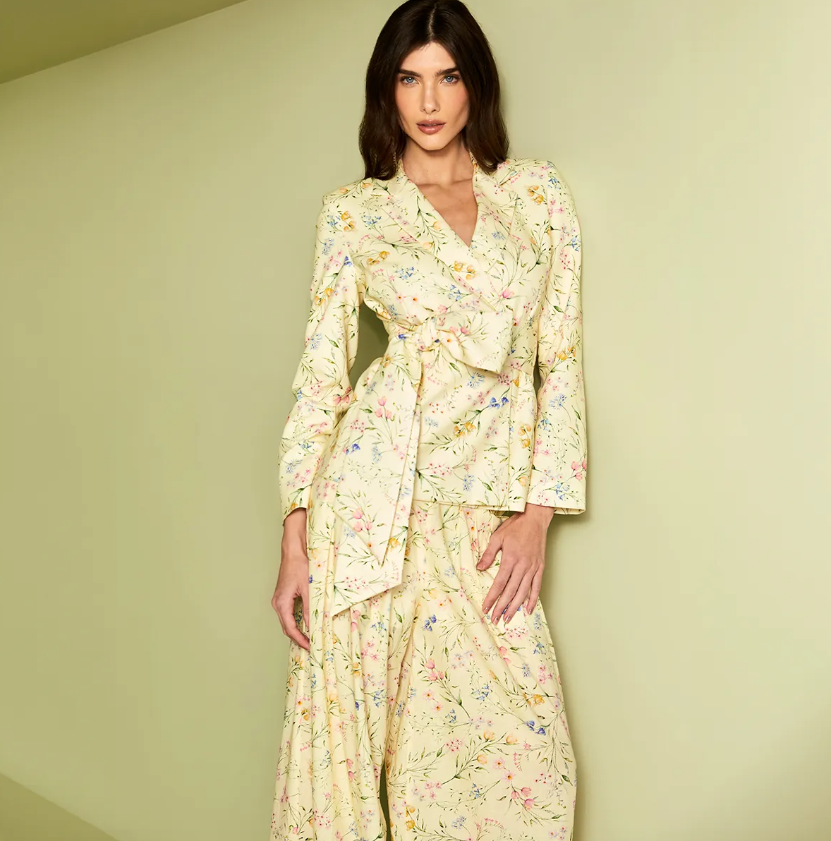 Woman wearing a floral dress against a plain background