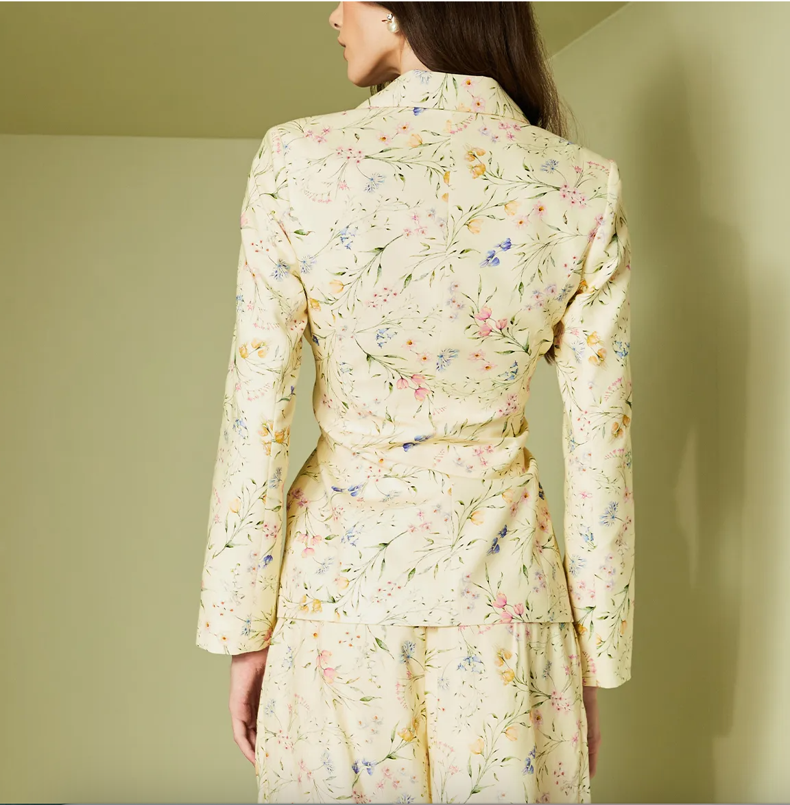 Woman wearing a floral dress against a plain background