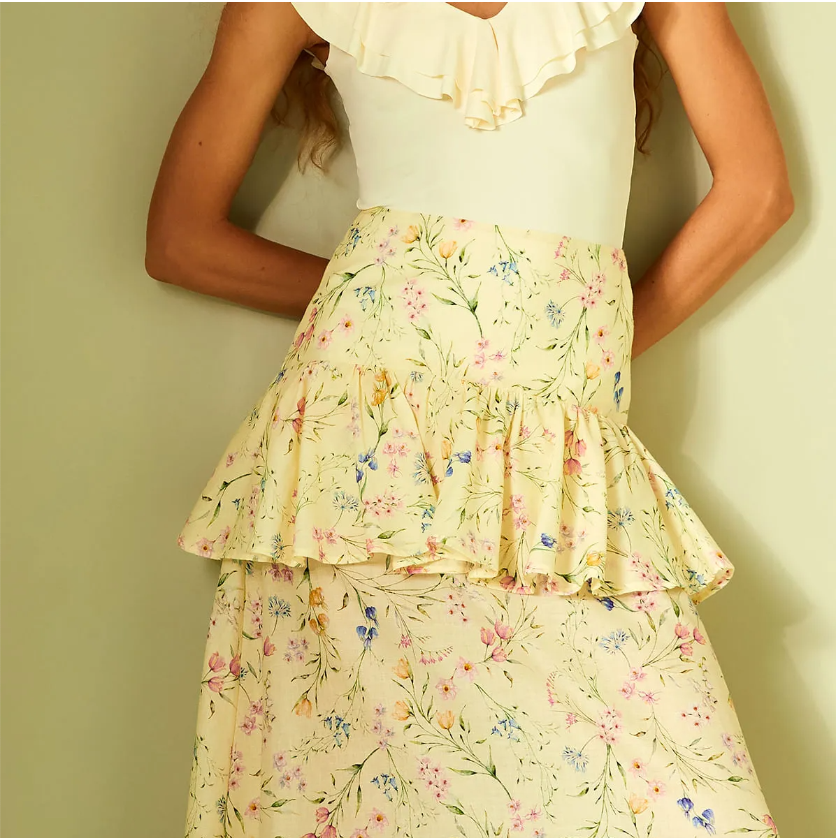 Floral tiered skirt worn by a person against a plain background