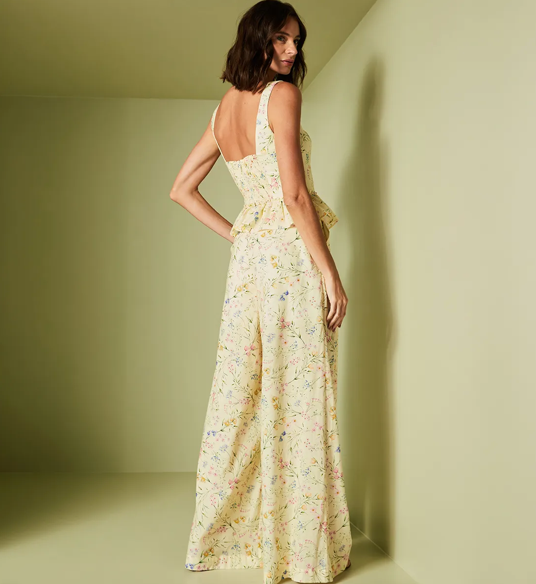 Woman wearing a floral dress against a plain background