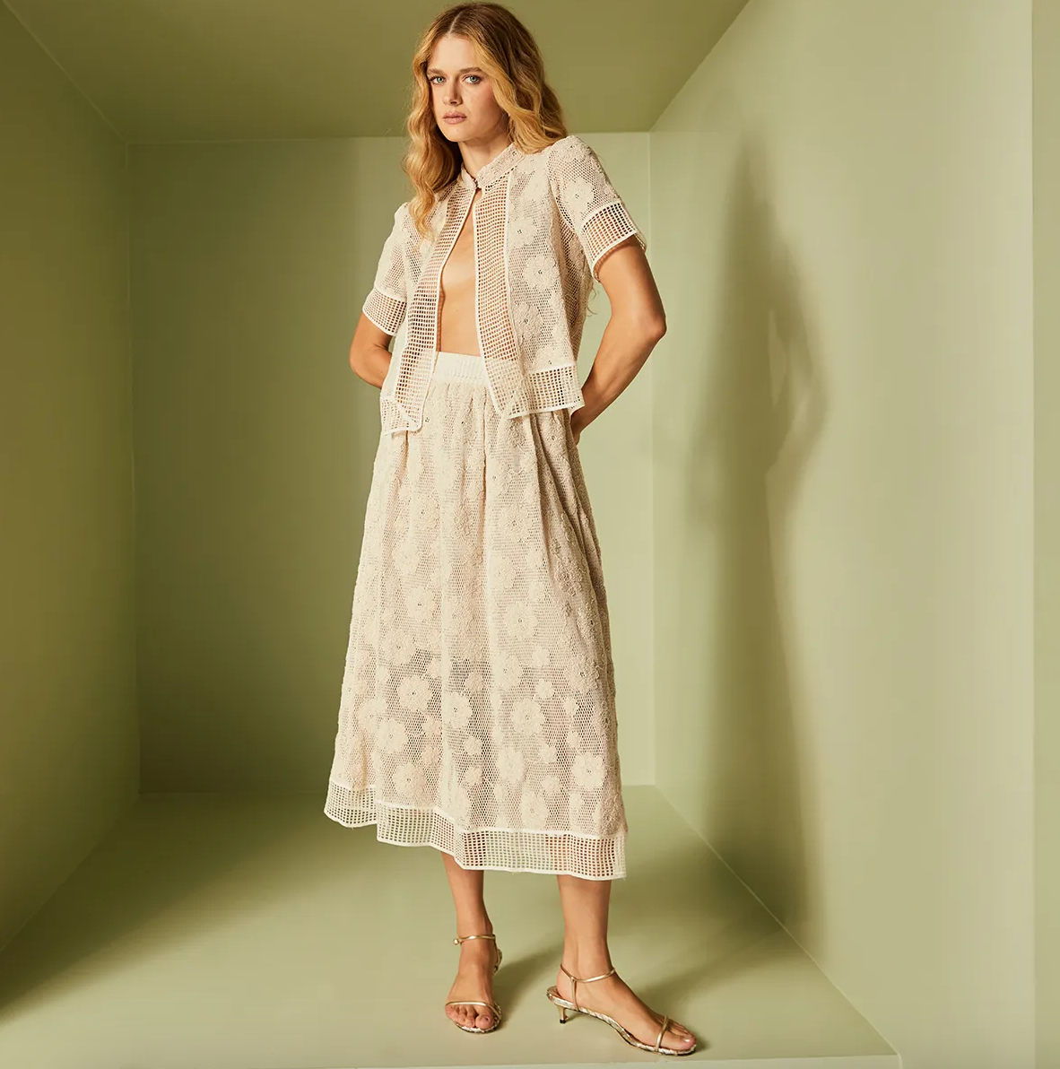 Woman wearing a white lace dress in a minimalistic setting