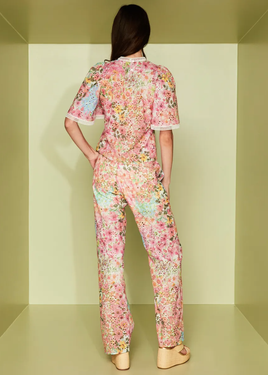 Person wearing a floral pajama set in a minimalistic room.