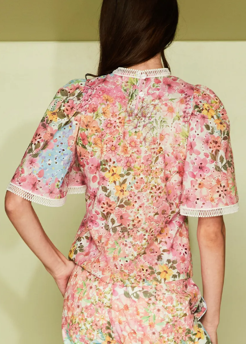Woman wearing a floral dress against a plain background