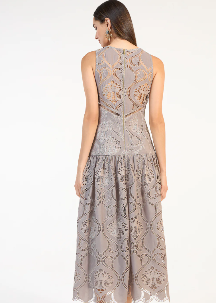 Woman wearing a sleeveless lace dress on a white background