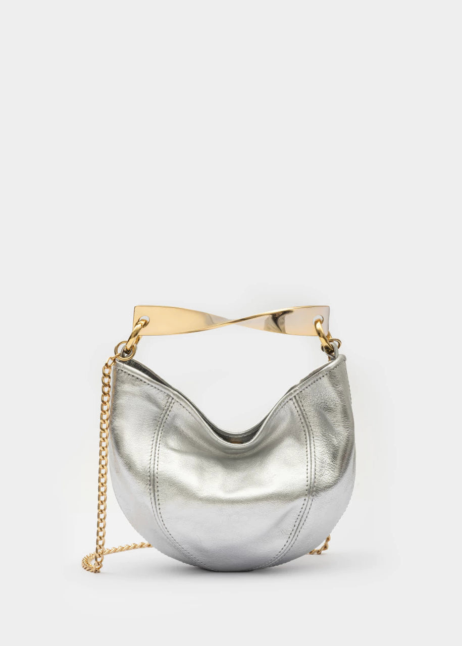 Silver handbag with gold chain and handle on a light gray background
