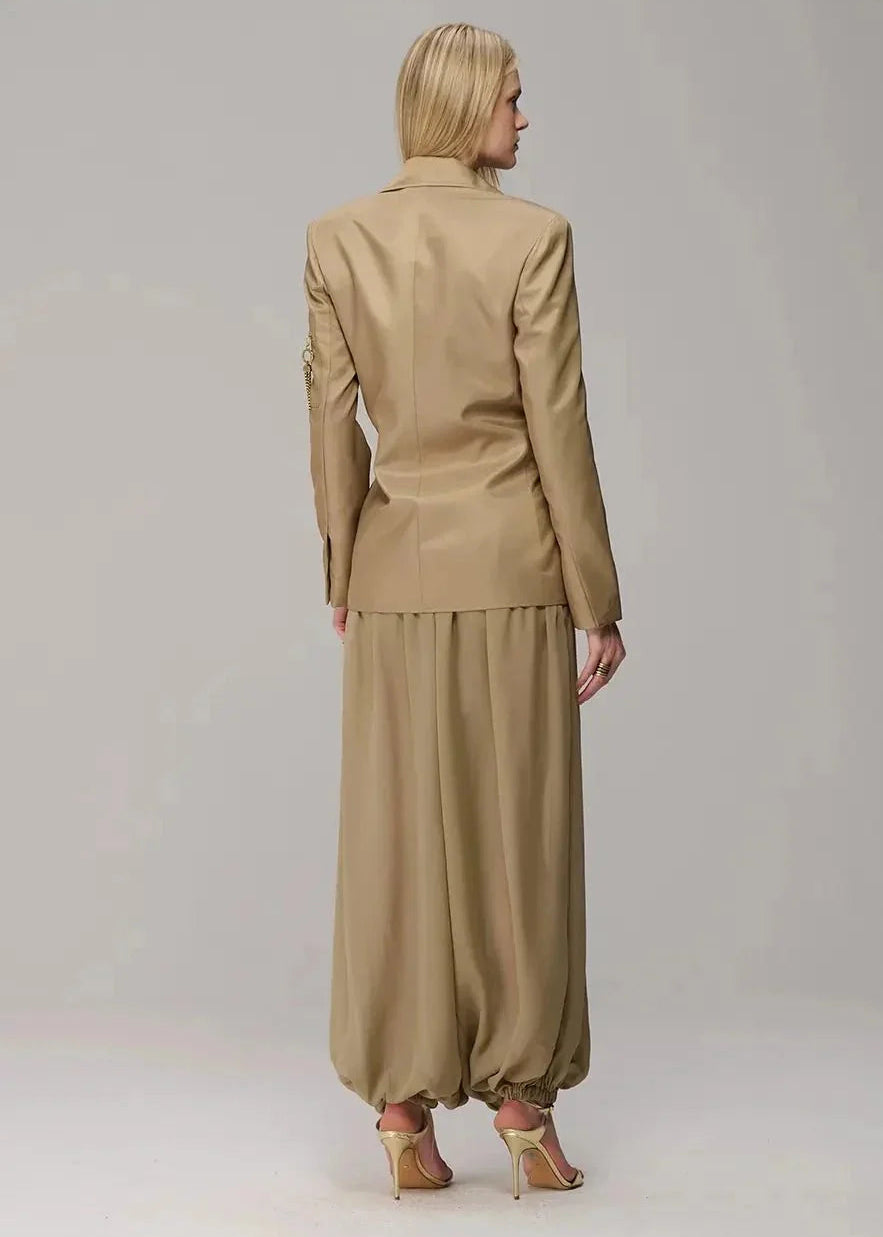 Woman wearing a beige suit on a plain background