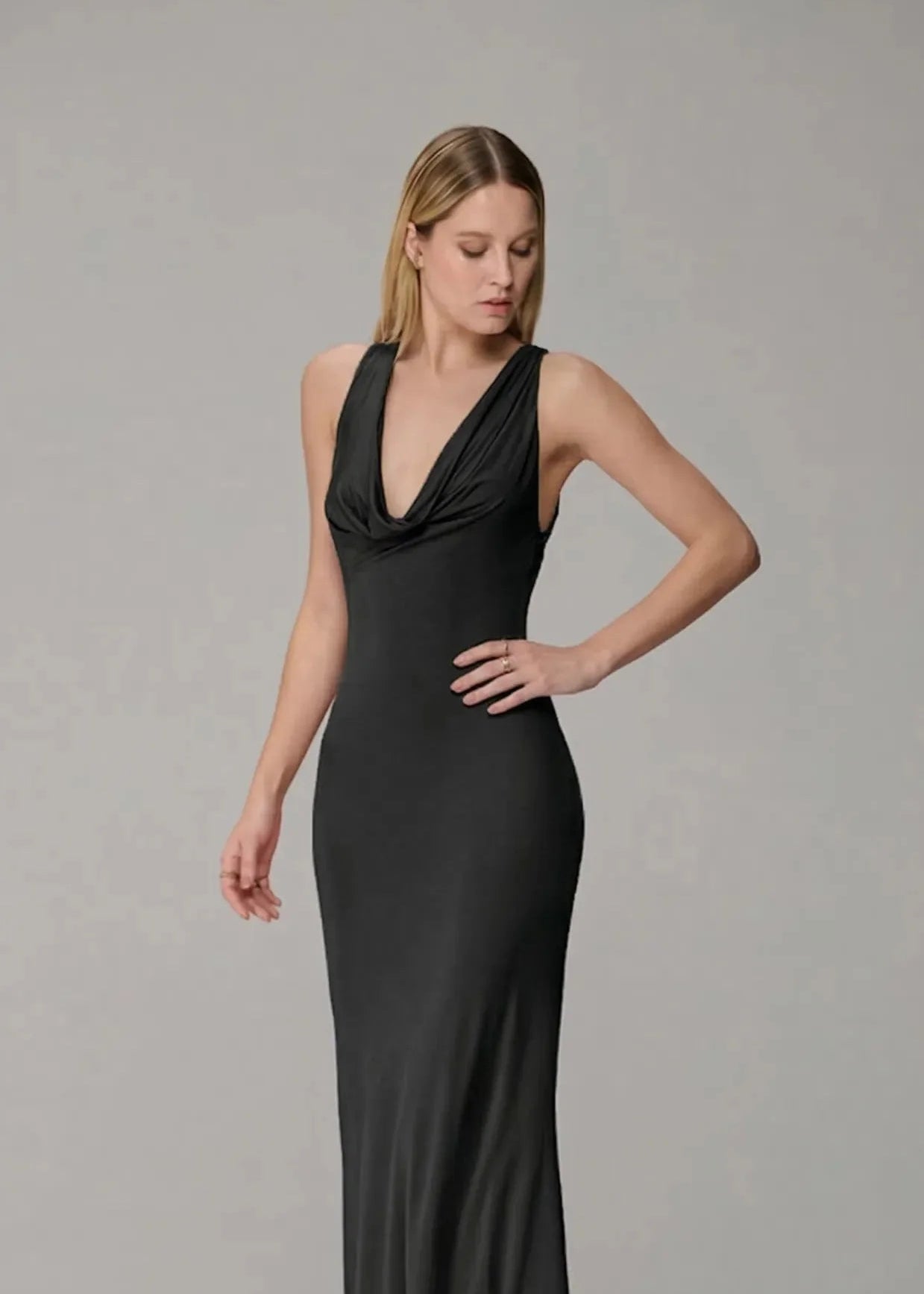 Woman wearing a black evening gown against a gray background