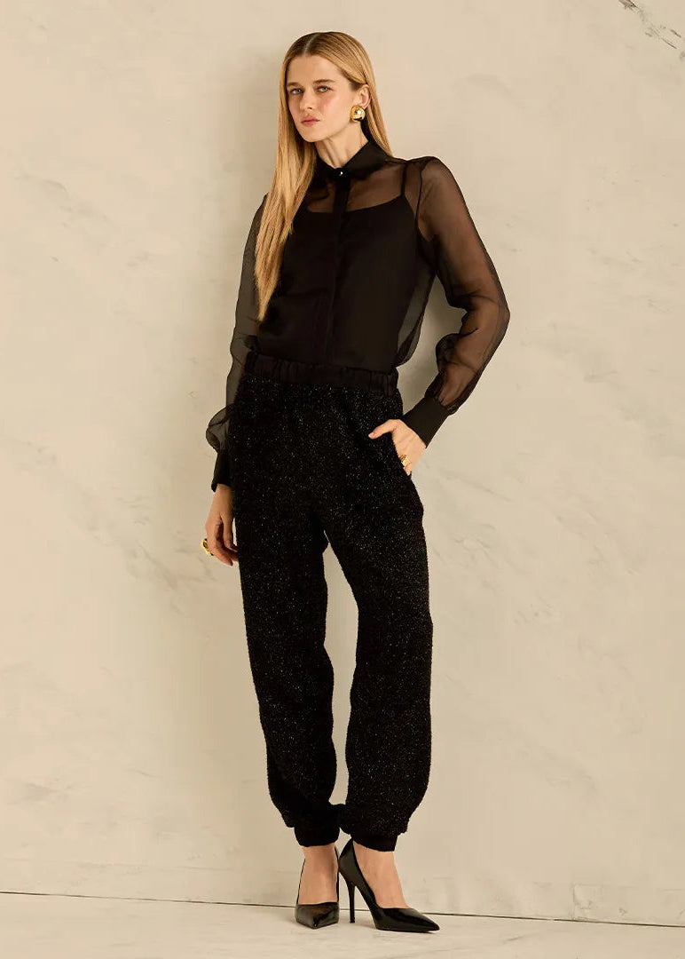 Woman wearing a black outfit against a neutral background