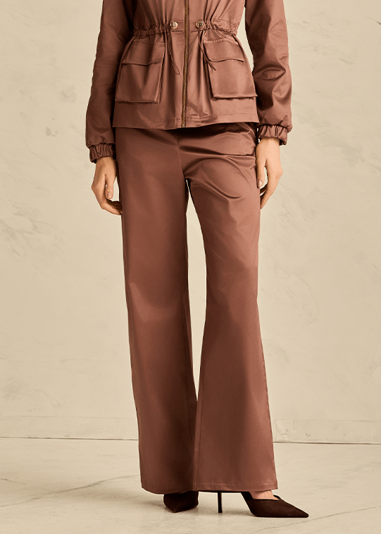 Woman wearing a brown outfit against a neutral background