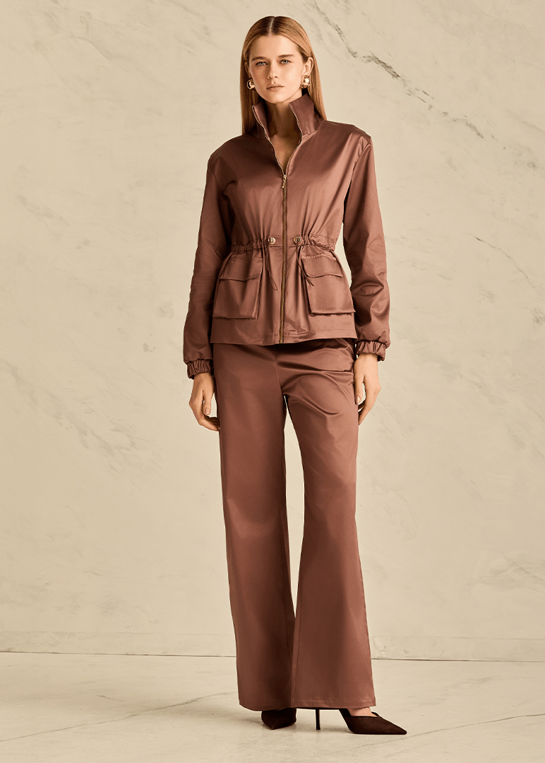 Woman wearing a brown outfit against a neutral background