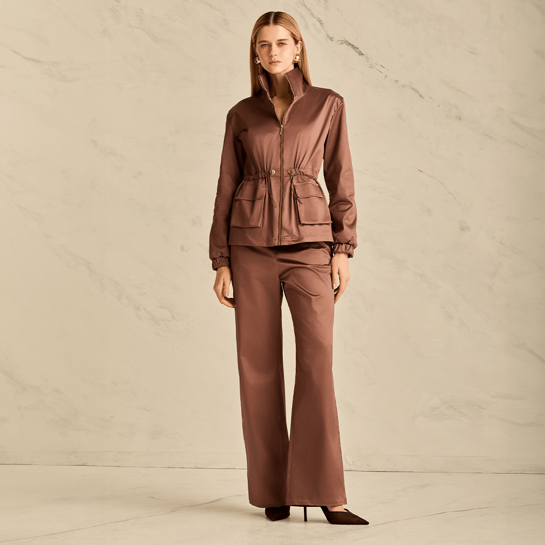 Woman wearing a brown outfit against a neutral background