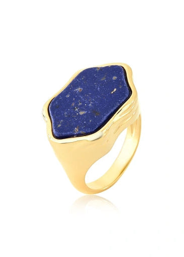 Gold ring with a blue stone on a white background