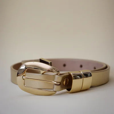 Beige belt with a gold buckle on a light gray background