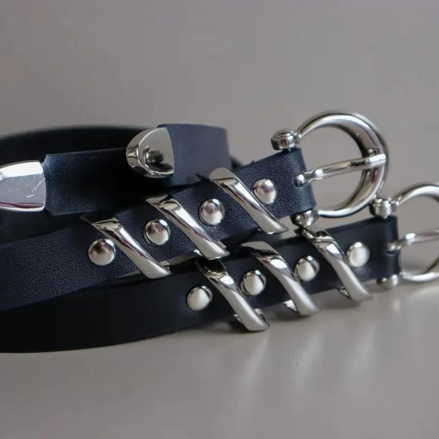 Navy leather dog collars with silver hardware on a gray background