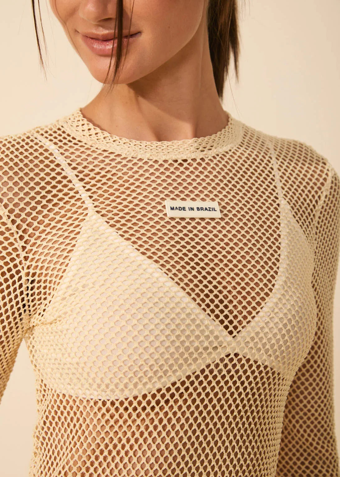 Beige fishnet top with 'Made in Brazil' label on a neutral background