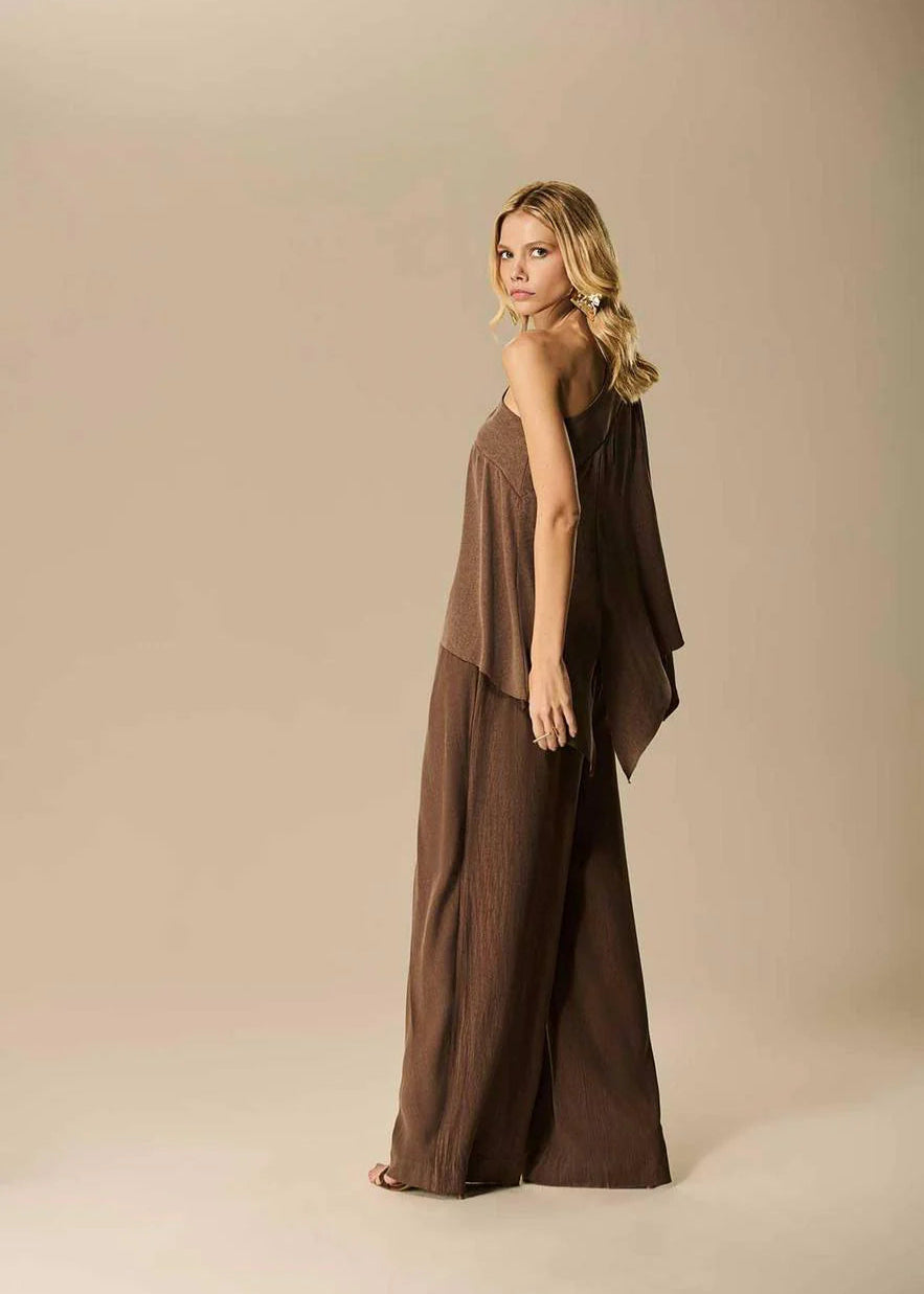 Woman wearing a brown dress against a beige background