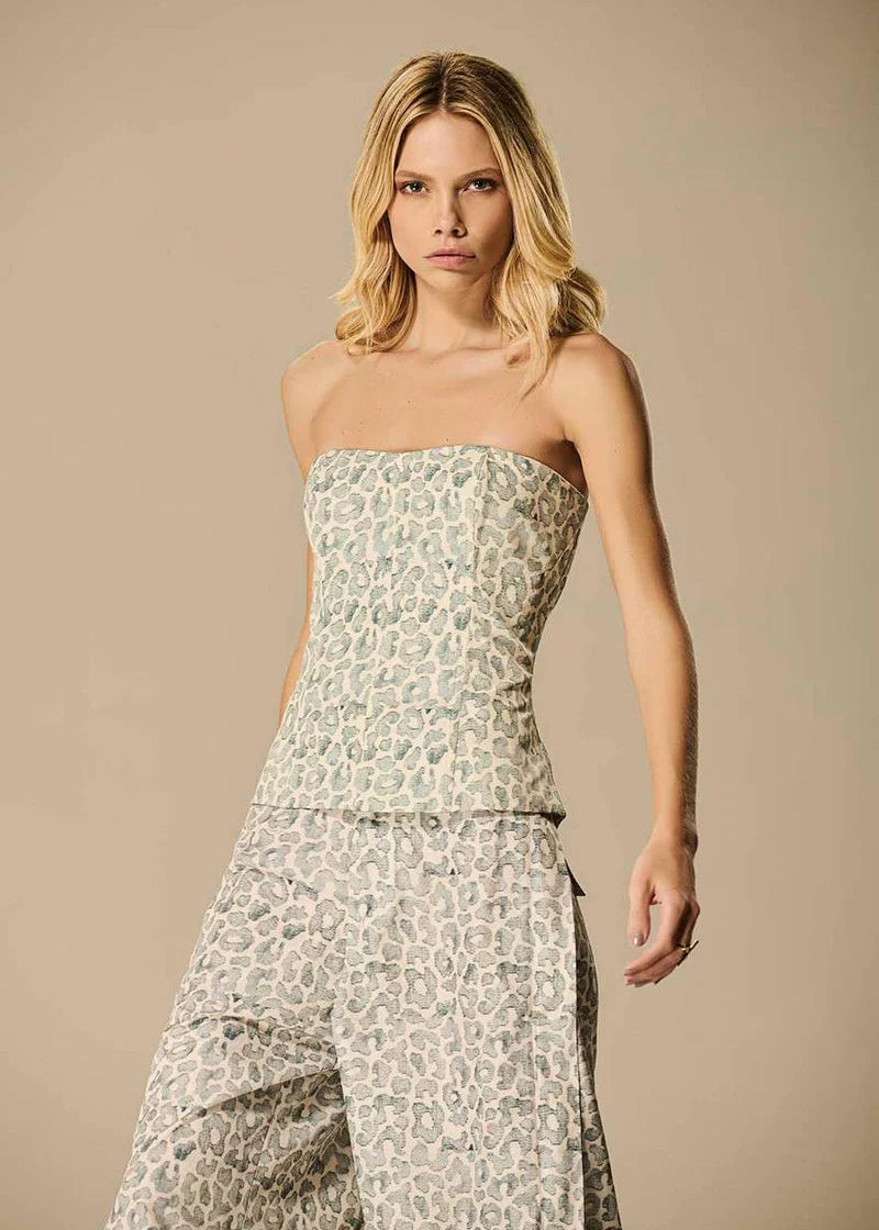 Woman wearing a strapless floral dress against a beige background