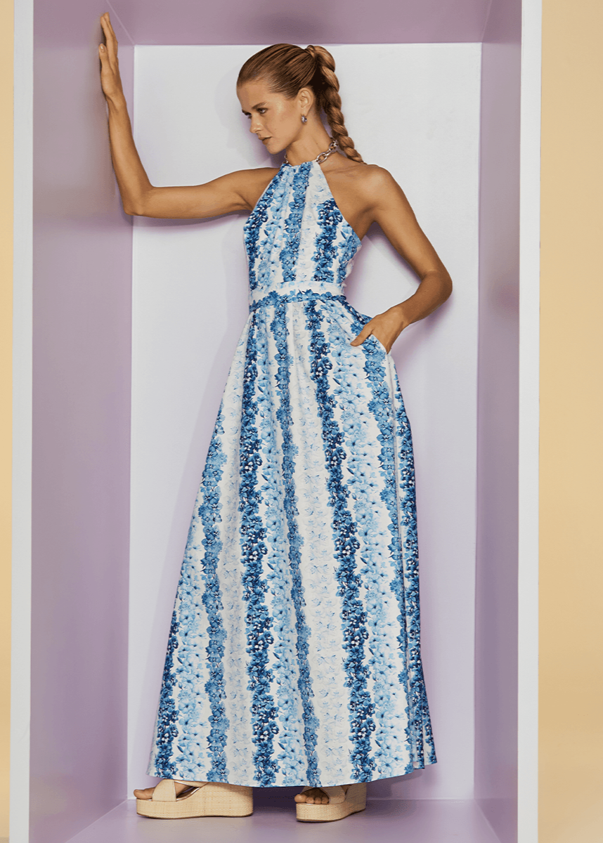 Woman wearing a blue and white patterned dress against a plain background
