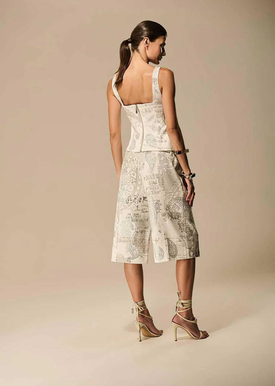 Woman wearing a light-colored dress with floral patterns on a beige background