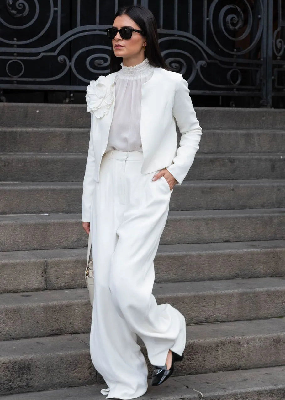 Woman in a white outfit standing on steps