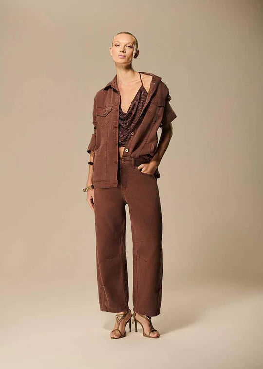 Woman wearing a brown outfit against a beige background