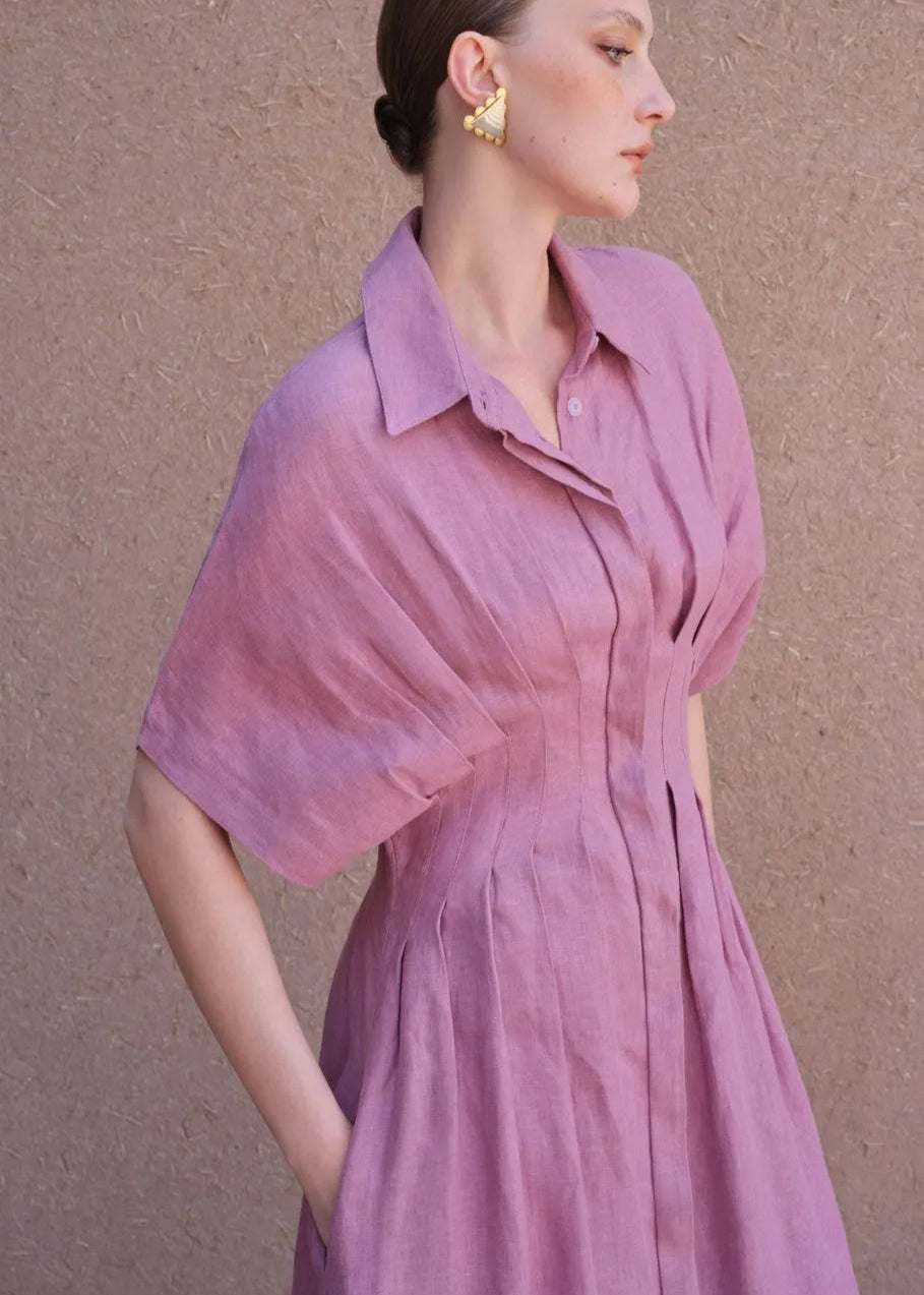 Woman wearing a pink dress against a beige background