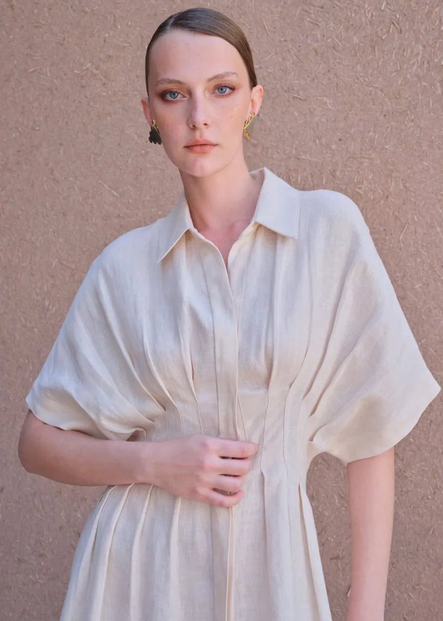 Woman wearing a light-colored dress against a beige background