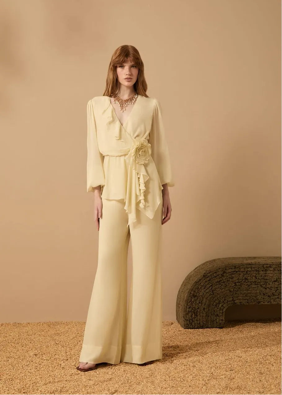 Woman wearing a light yellow outfit against a beige background