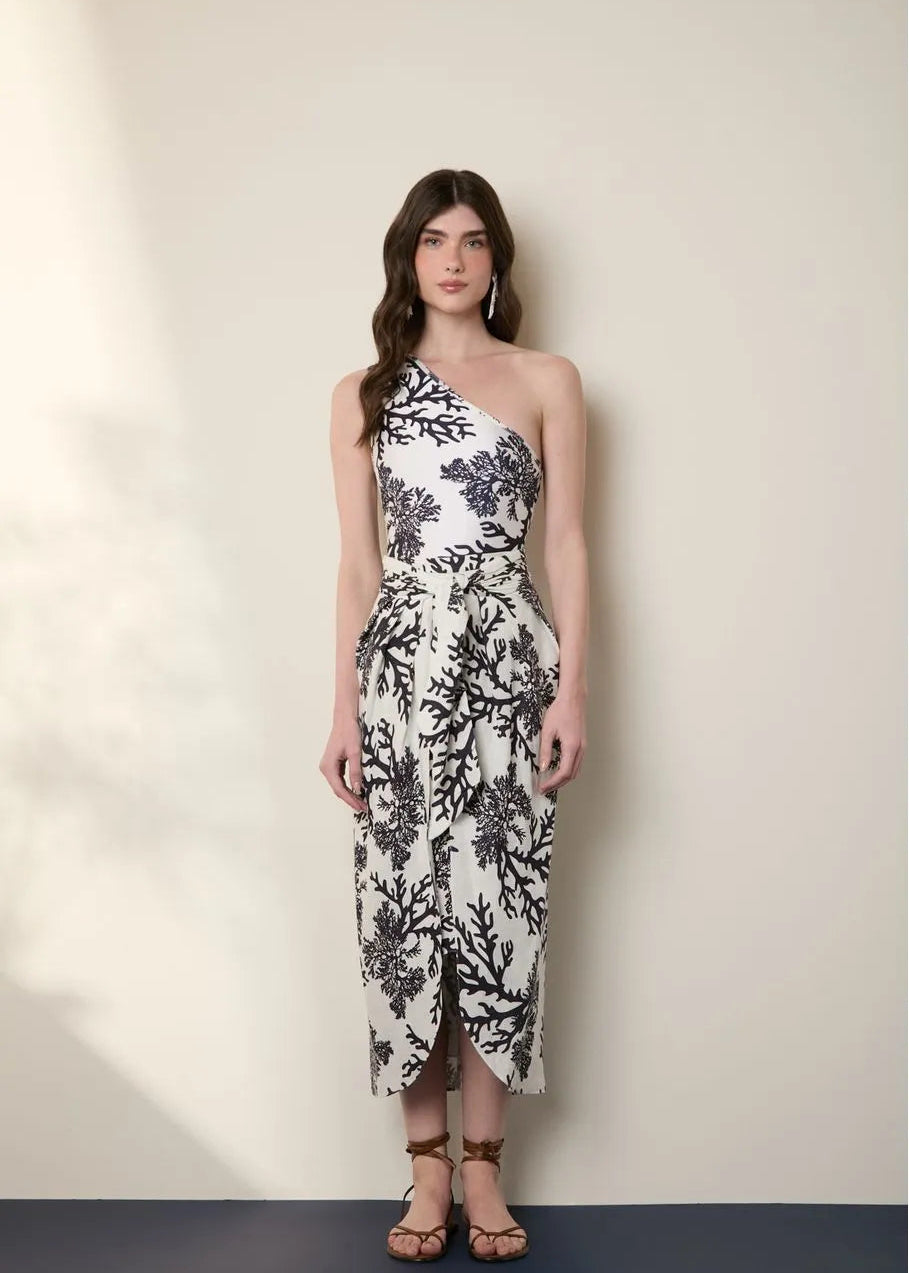 Woman wearing a black and white floral dress against a plain background