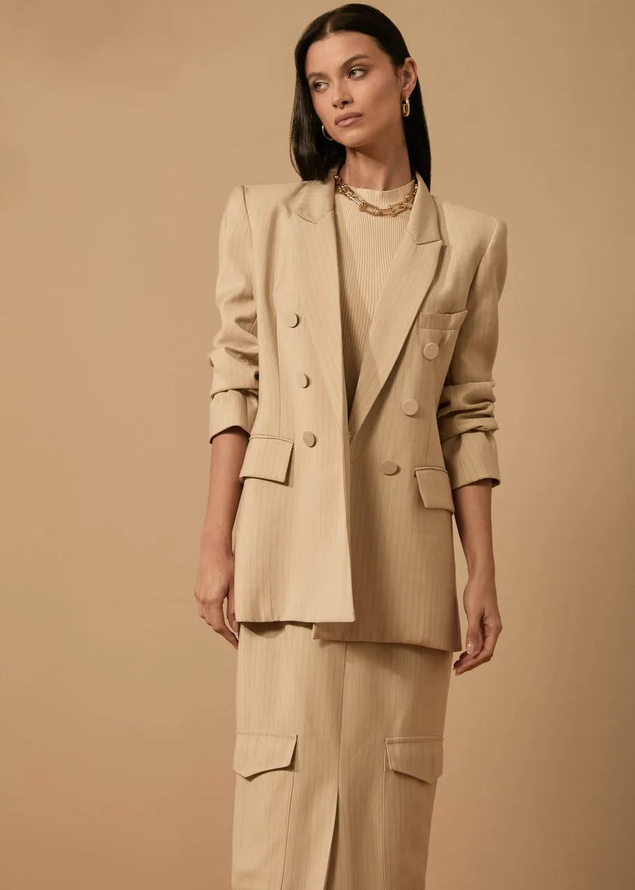 Woman wearing a beige suit against a beige background
