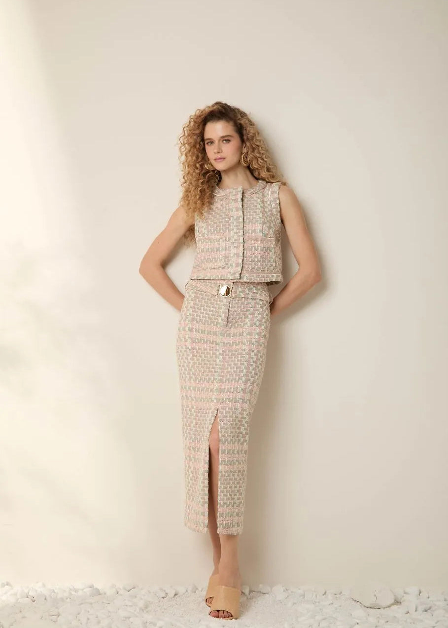 Woman wearing a patterned sleeveless top and skirt set on a light background