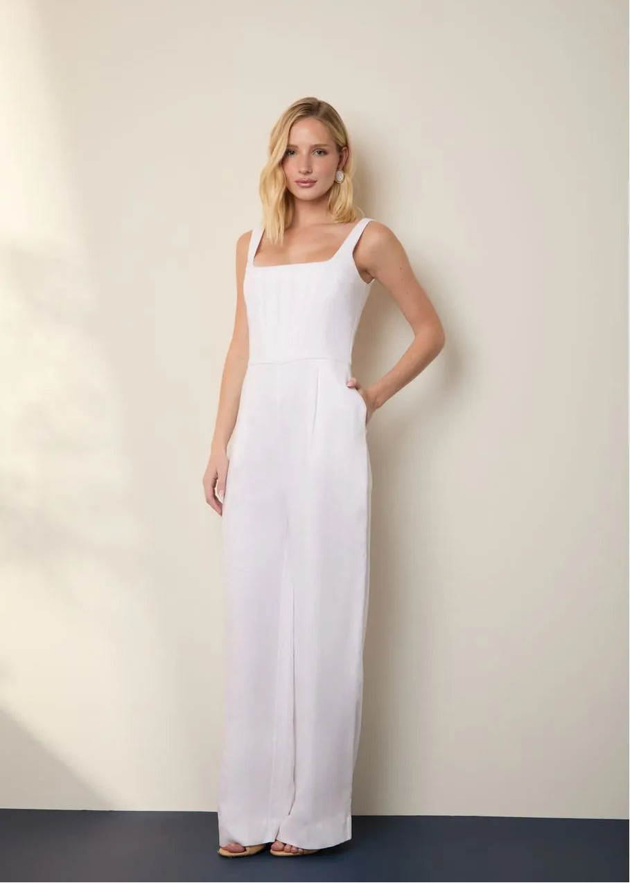 Woman wearing a white sleeveless dress against a plain background