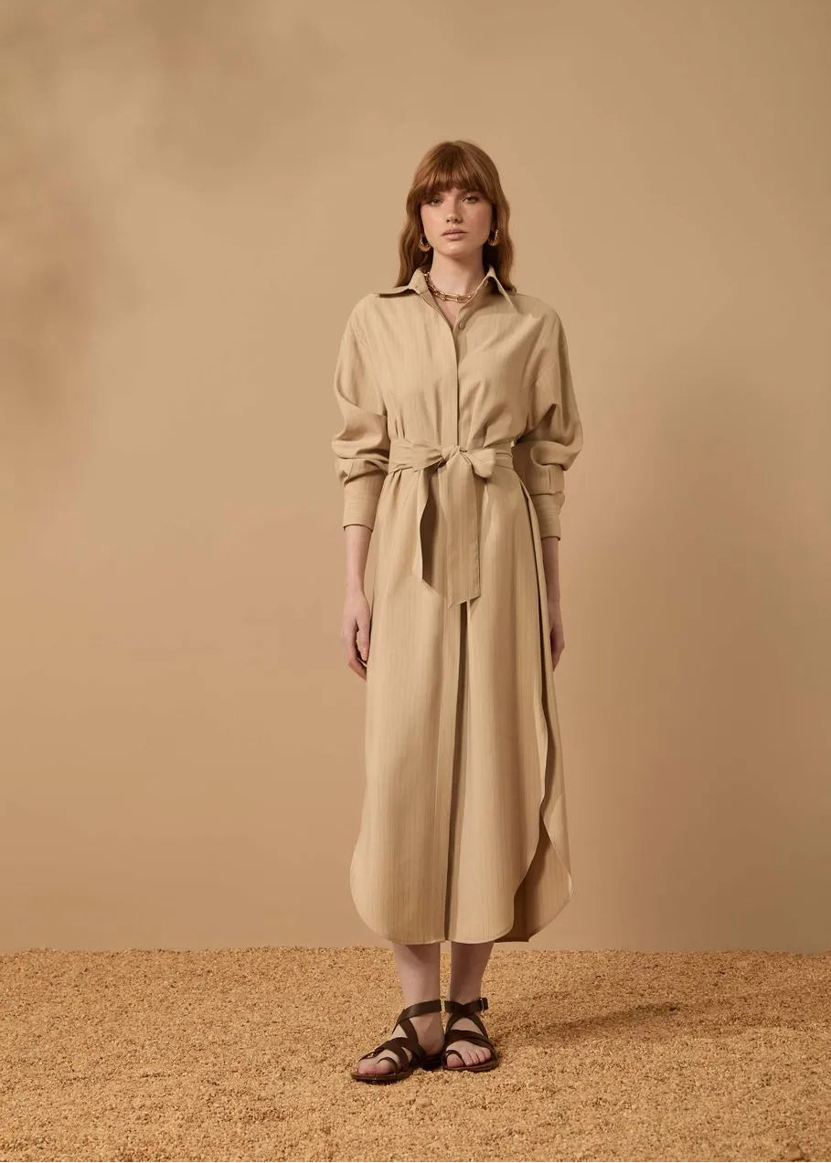 Woman wearing a beige dress against a matching background