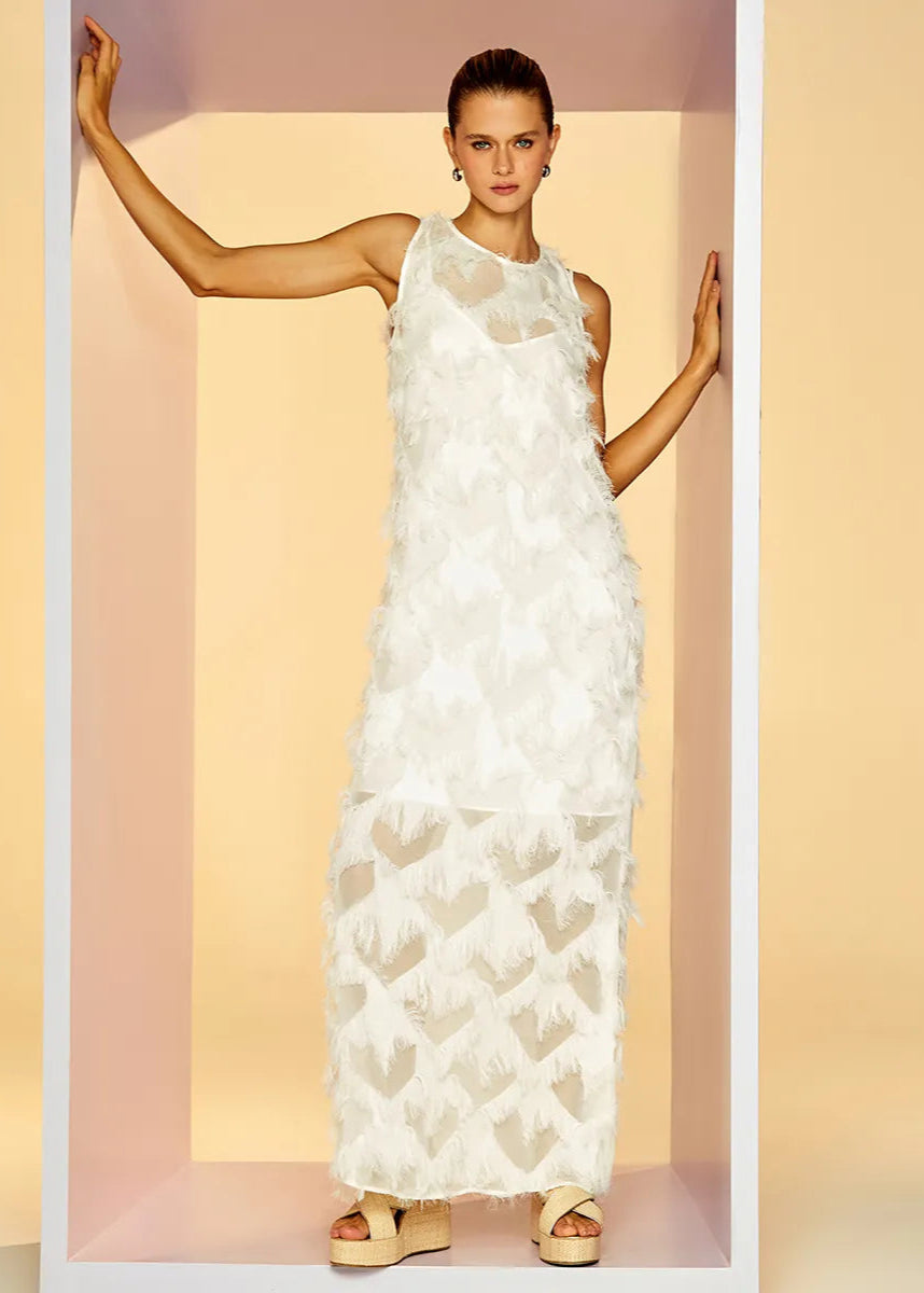 Woman wearing a white floral dress against a soft pink background