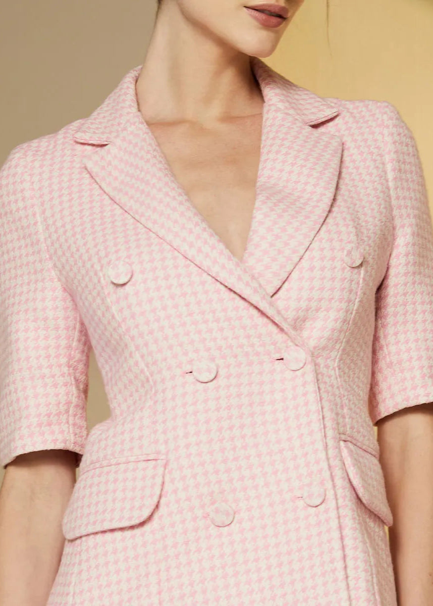 Pink checkered blazer worn by a person on a beige background