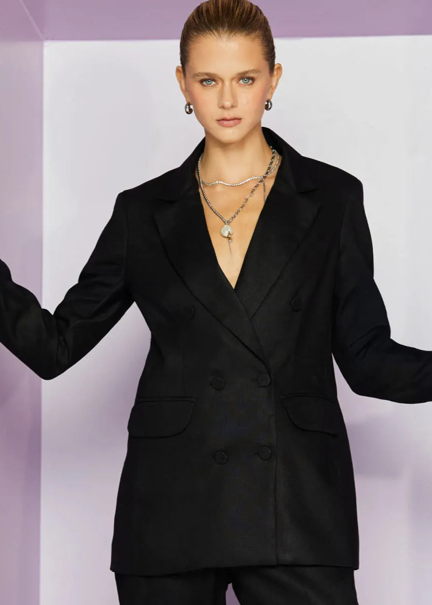 Woman wearing a black suit against a white background