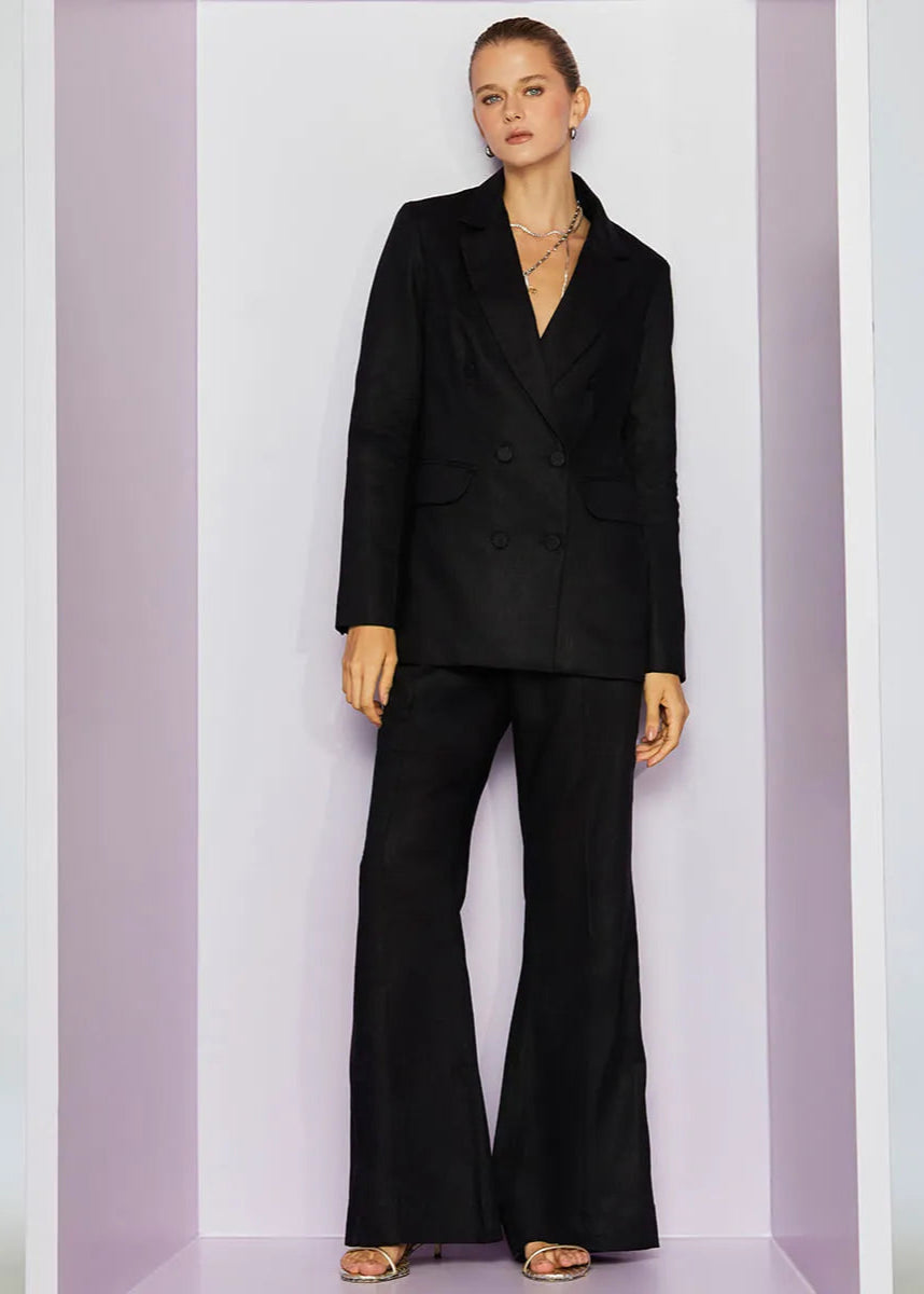 Woman wearing a black suit standing against a white background