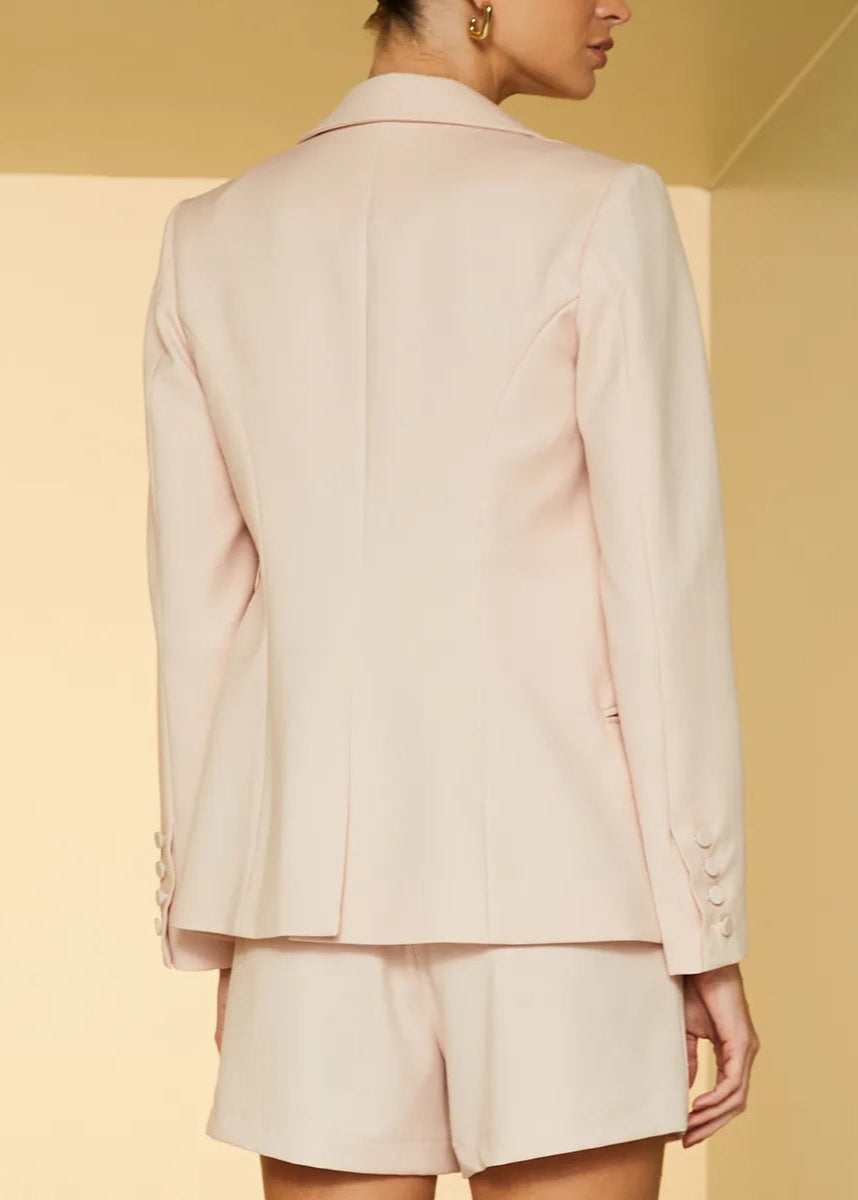 Person wearing a beige suit against a yellow background