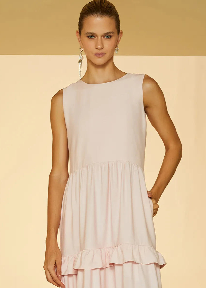 Woman wearing a light pink dress against a beige background