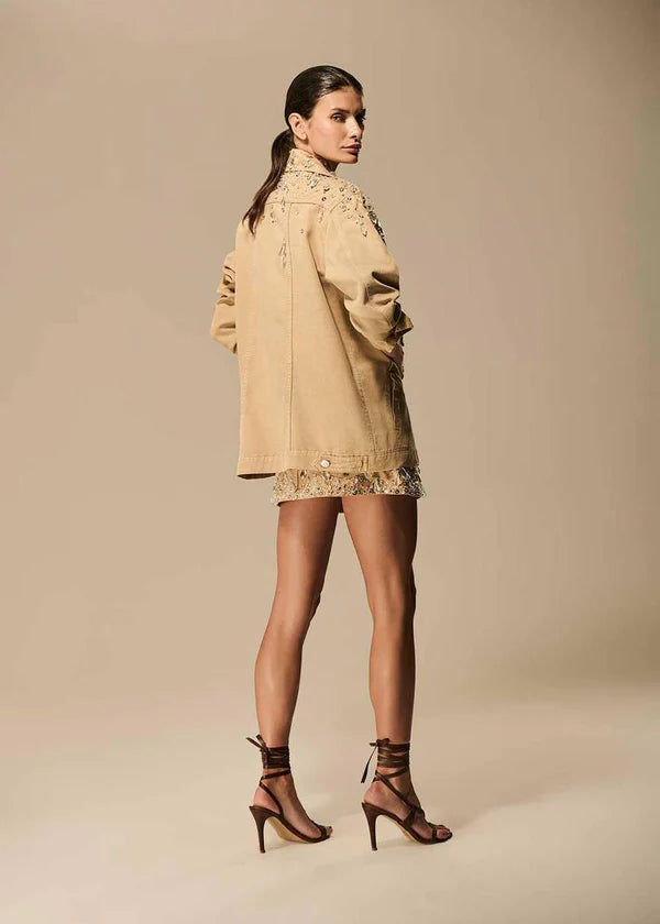 Woman wearing a beige dress with lace details on a beige background