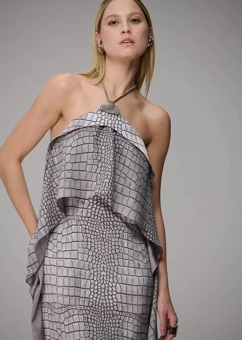 Woman wearing a gray patterned halter dress against a gray background