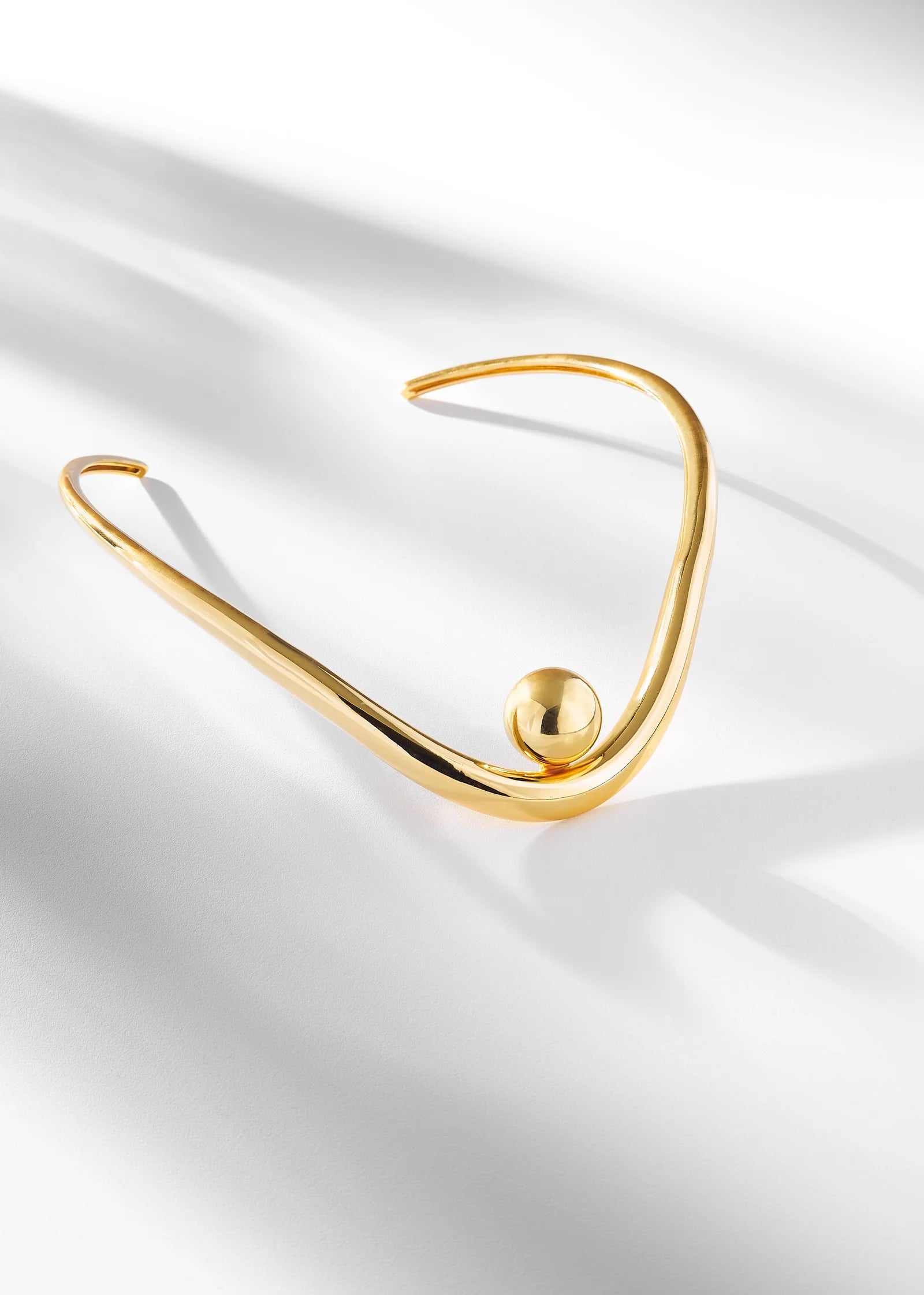 Gold necklace on a white fabric background